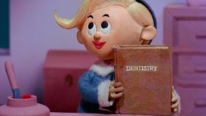 Hermey the Elf holding a book about dentistry