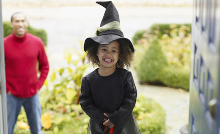 Girl in witch costume trick or treats