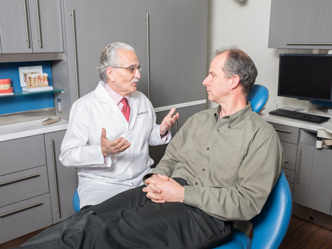 Man discussing oral cancer screening with his dentist